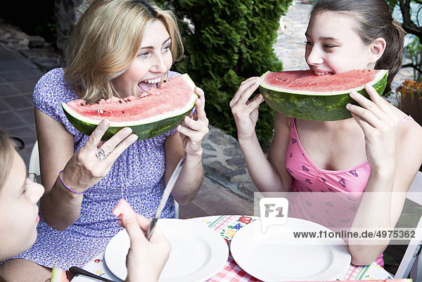 Mother and daughter eating watermelon