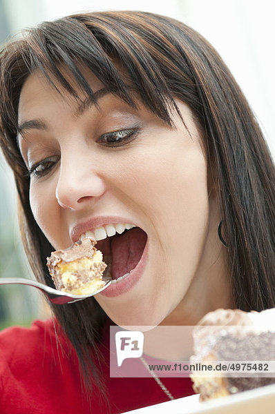 Greedy woman eating piece of cake