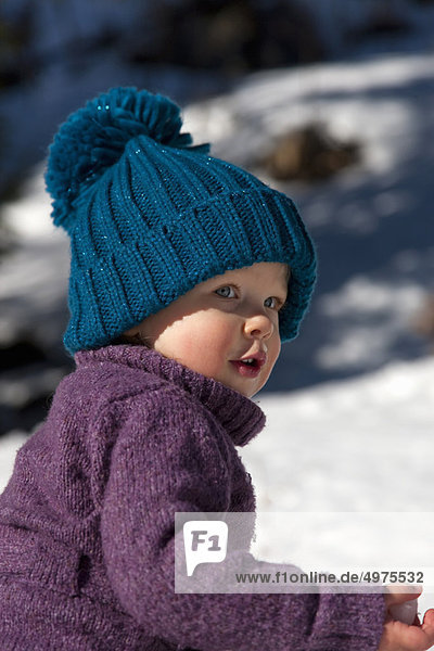 Little girl with big hat playing in snow