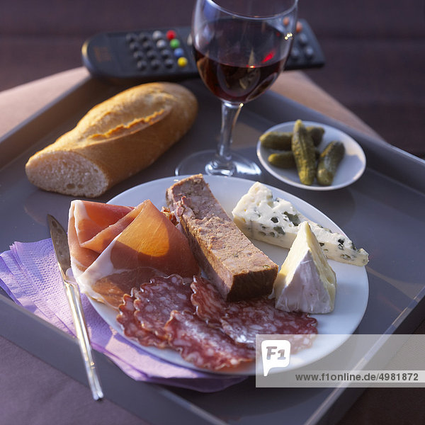 T.V Abendessen mit einem Teller mit Aufschnitt und Käse und ein Glas Rotwein