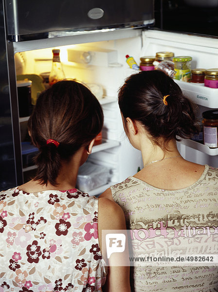 Girls looking in a refrigerator