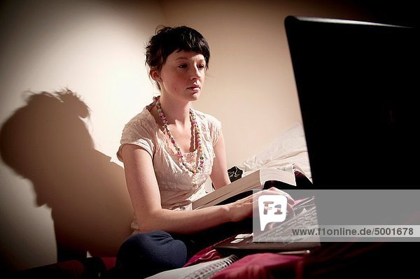 Interior  zu Hause  Frau  Computer  Notebook  Großbritannien  arbeiten  Schlafzimmer  Student  jung  Universität