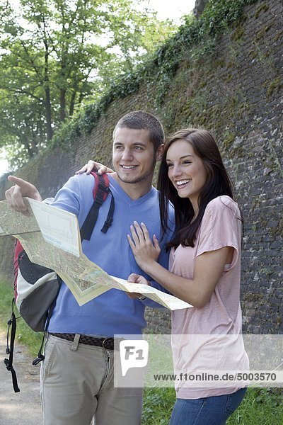 Young couple reading map outdoors