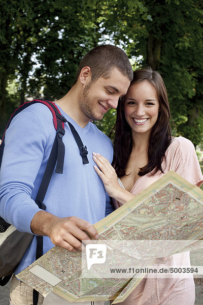 Young couple reading map outdoors