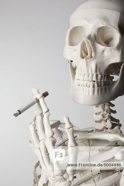 Ein Skelett  das eine Zigarette raucht.