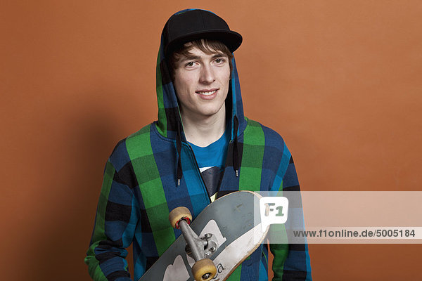 Ein Teenager mit Skateboard,  Porträt,  Studioaufnahme