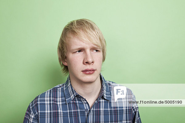Ein Teenager schaut zur Seite mit Verdacht  Porträt  Studioaufnahme