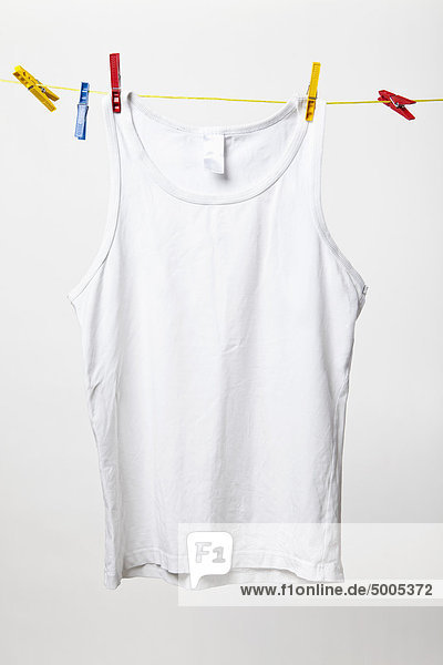 White tank top hanging on clothes line