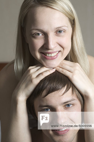 Eine Frau legt ihr Kinn auf den Kopf ihres Freundes  Porträt