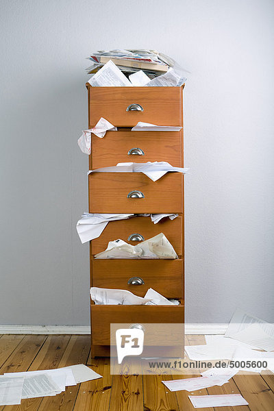 Ein Schrank gefüllt mit überfließenden Papieren.