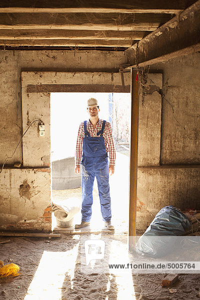 Ein Handarbeiter steht in einer Tür  Porträt