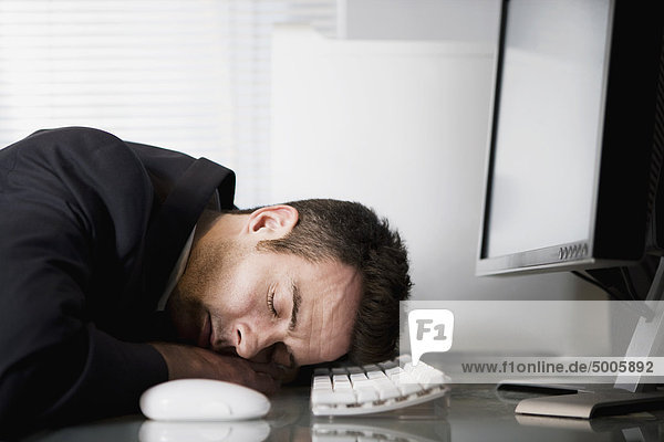 A businessman asleep at his desk