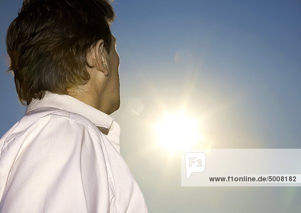 Mann im Freien schaut zur Sonne