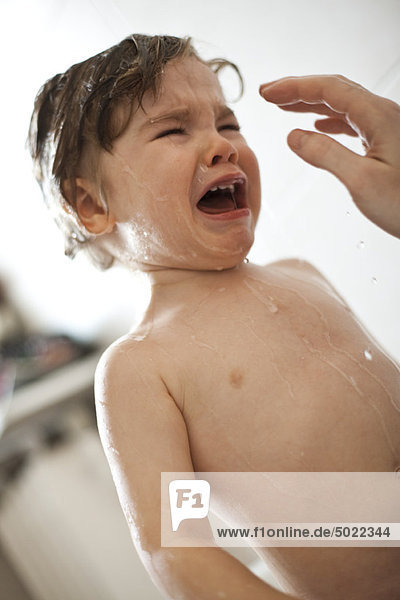 Kleinkind Junge weint in der Badewanne