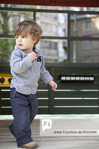 Kleiner Junge  der auf dem Spielplatz läuft