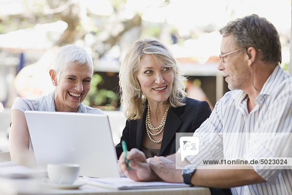 Business people using laptop outdoors