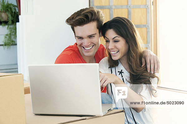 Lächelndes Paar mit Laptop zusammen