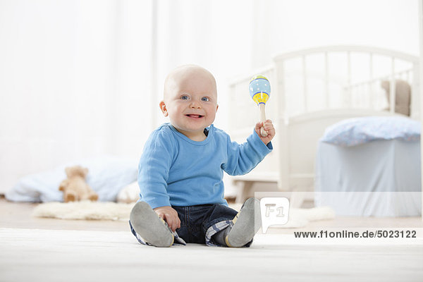 Baby boy playing with rattle