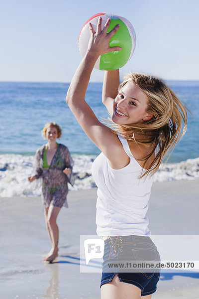 Frauen spielen mit dem Ball am Strand