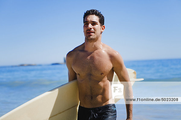 Mann tragen Strand Surfboard