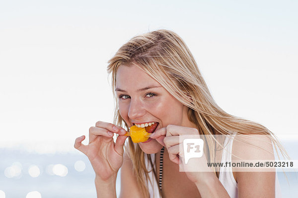 Woman eating popsicle on beach