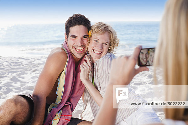 Woman taking picture of friends on beach