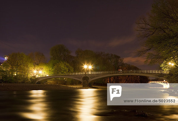 Lit bridge over river at night