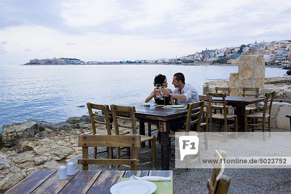Couple sitting at waterfront cafe