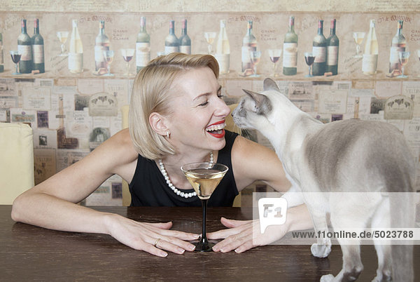 Frau trinkt Martini mit Katze