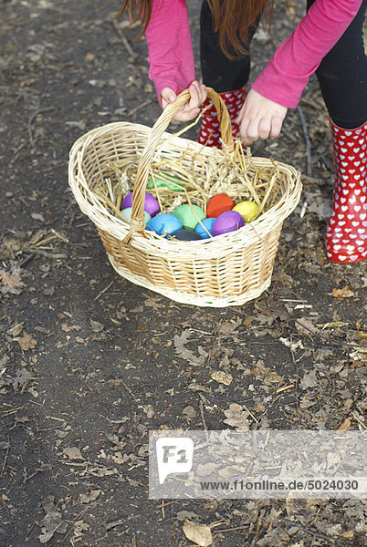 Girl carrying basket of Easter eggs