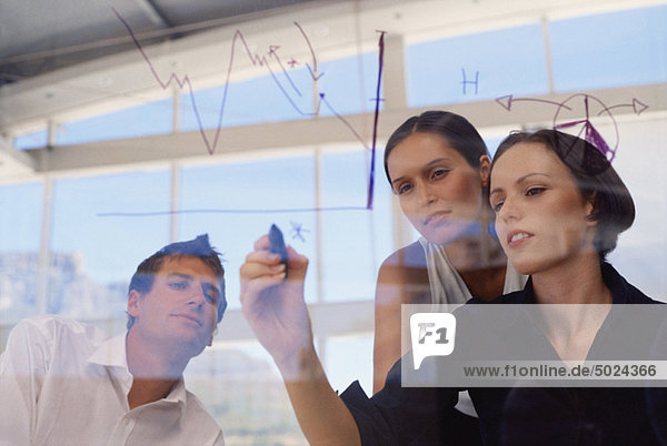 Businesswoman drawing graph on glass