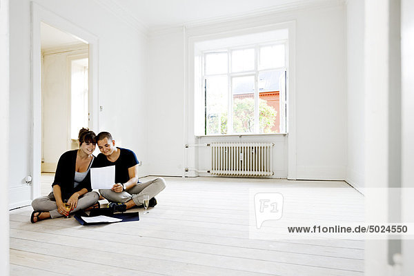 Couple reading papers in new home
