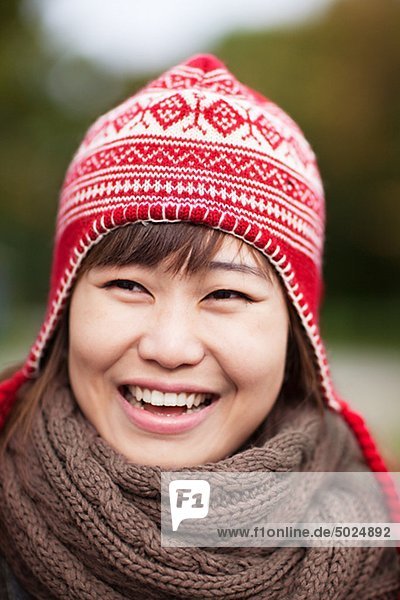 Portrait of happy young Woman wooly Hut trägt