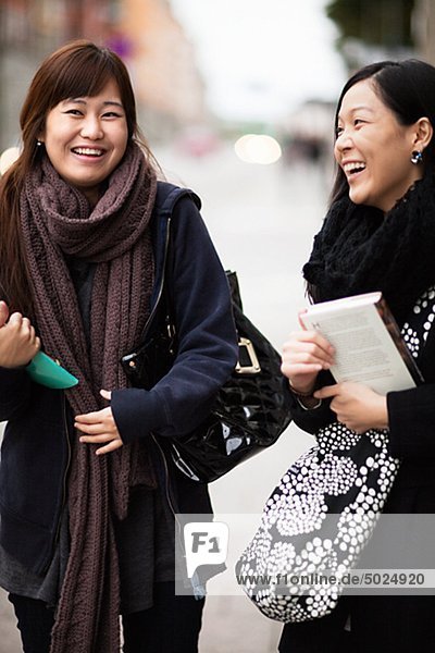 Zwei junge Frauen lachend auf Straße