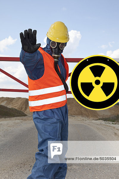 Deutschland  Mann in Arbeitsschutzbekleidung bei radioaktivem Warnsymbol