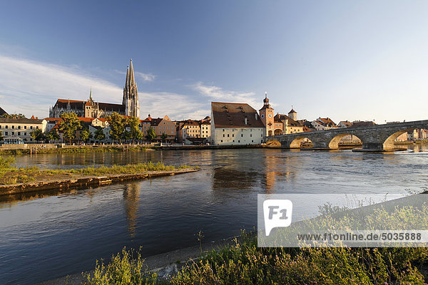 Germany,  Bavaria,  Upper Palatinate,  Regensburg,  View of cathedral and old stone bridge crossing Danube river