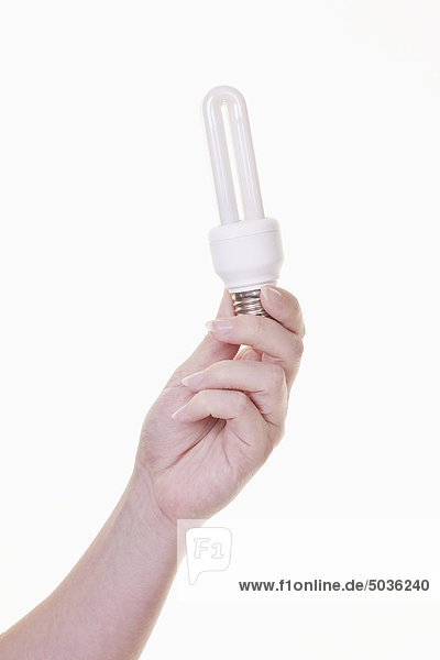 Hand der Frau mit Glühbirne auf weißem Hintergrund  Nahaufnahme
