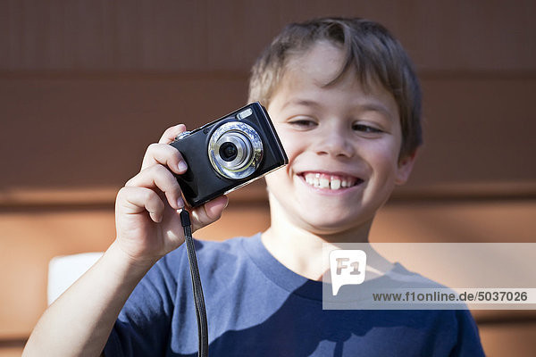 Smiling young boy taking a photograph. Gimli  Manitoba  Canada.