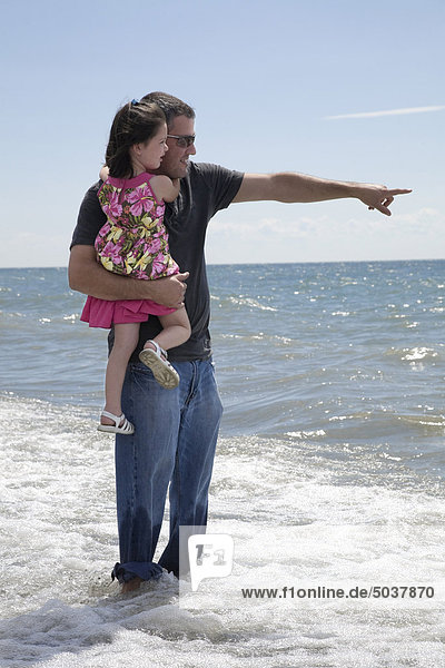 Vater seiner Tochter hält und stehen in der Brandung am Seeufer  Ontario  Kanada