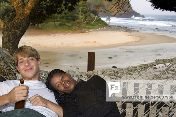 Ein paar entspannt in einer Hängematte von der Strand  Transkei  South Africa