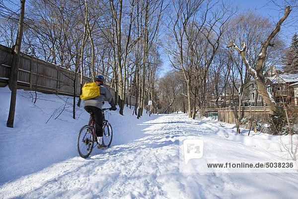Mann Radfahren auf Schnee bedeckten Weg im Winter  Toronto  Ontario  Kanada
