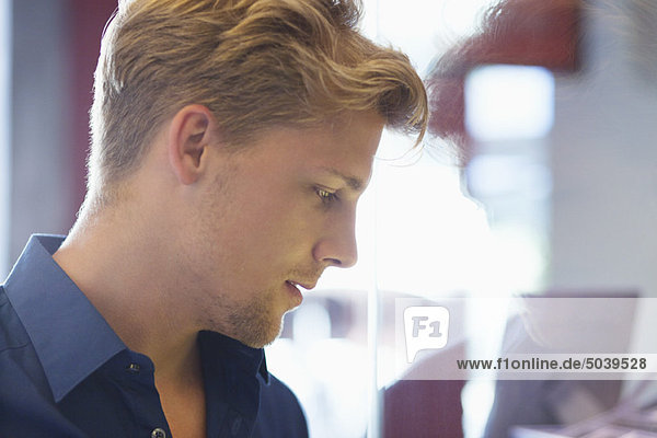 Side profile of a young man doing window shopping