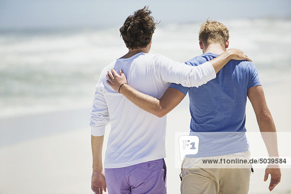 Rear view of two men walking with their arms around each other