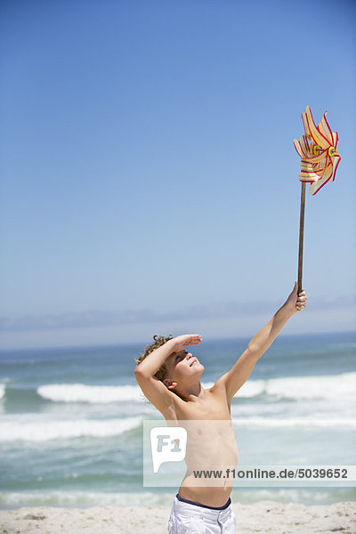 Boy holding a pinwheel on the beach