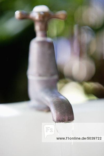 Close-up of running water from a brass faucet