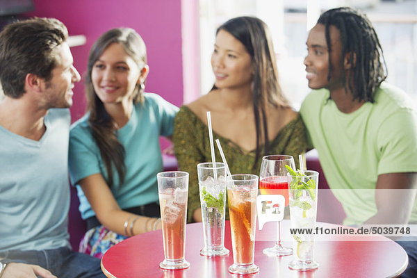 Freunde sitzen in einem Restaurant mit Fokus auf Getränke