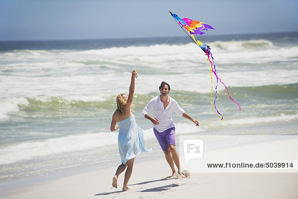 Couple flying kite on the beach