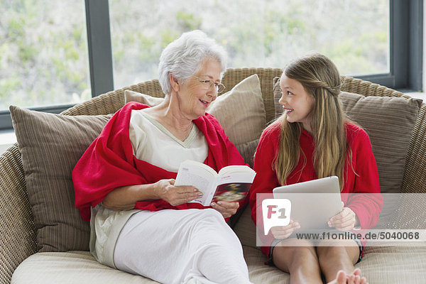 Senior woman and her granddaughter looking at each other and smiling