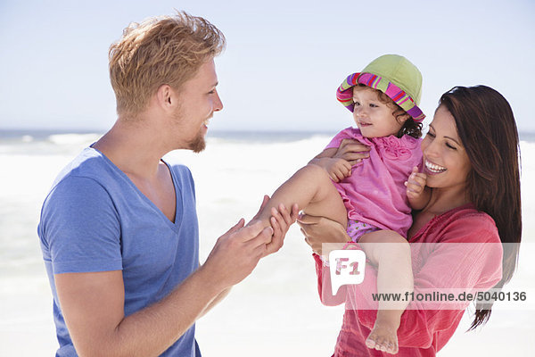 Pärchen genießen am Strand mit ihrer Tochter