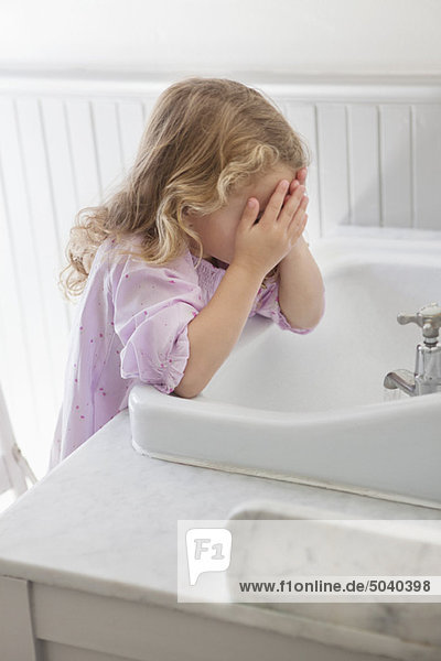 Süßes kleines Mädchen waschen Gesicht im Badezimmer Waschbecken